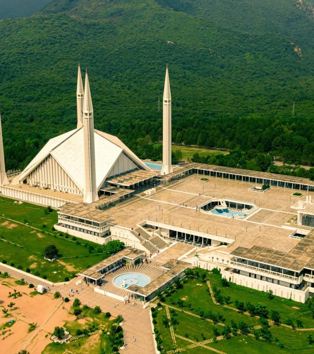Stunning aerial shot of Shah Faisal Mosque surrounded by lush greenery in Islamabad, Pakistan.
