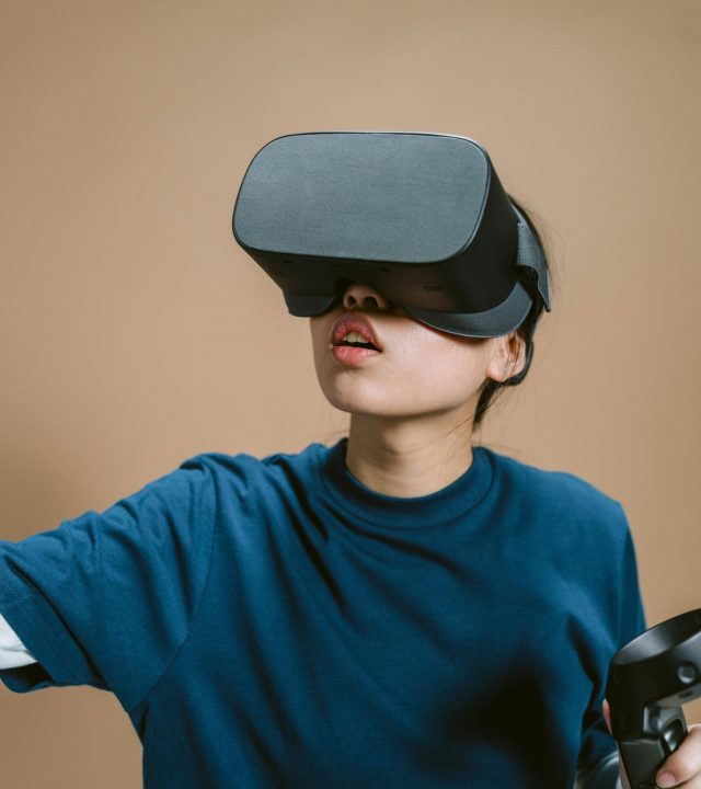 Person engaged in virtual reality gaming with VR headset and controller.